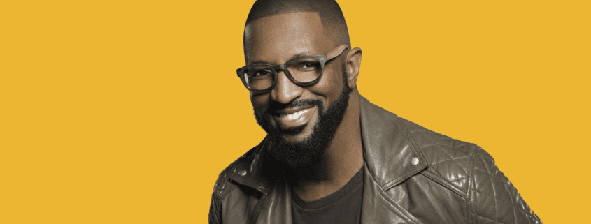 Man smiling against a yellow background.