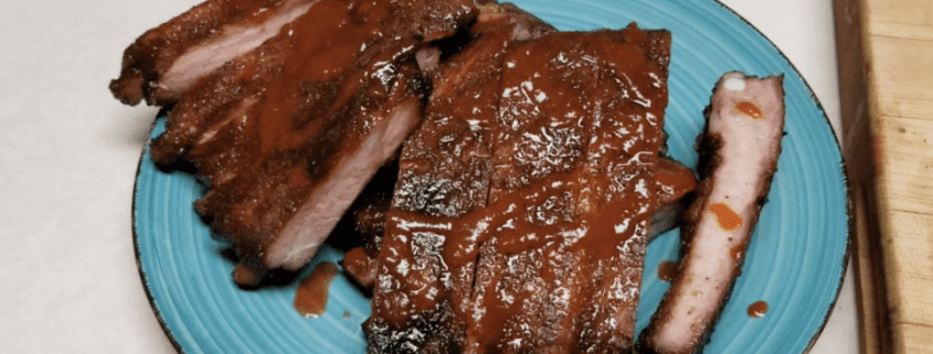 Barbecue ribs with sauce on blue plate.