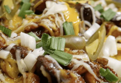 Loaded nachos with cheese and green onions.