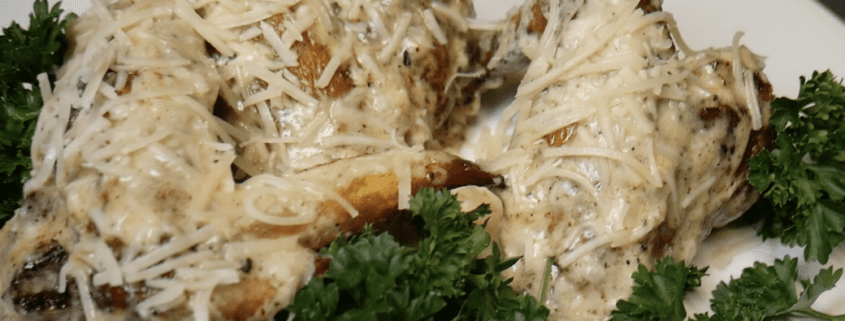 Chicken Alfredo with parsley garnish on plate.