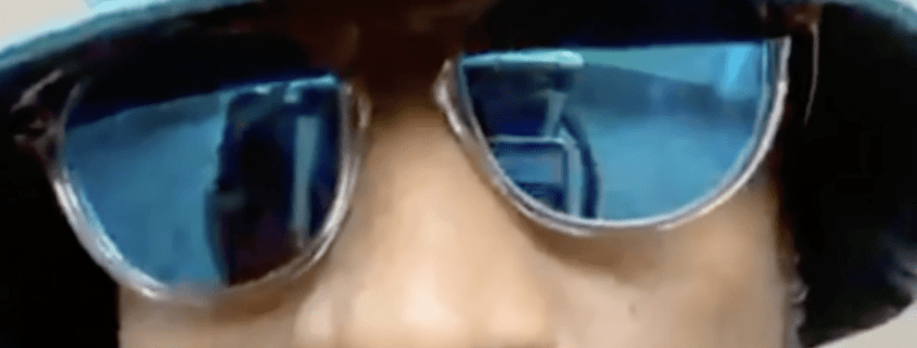 Man wearing reflective blue sunglasses close-up.